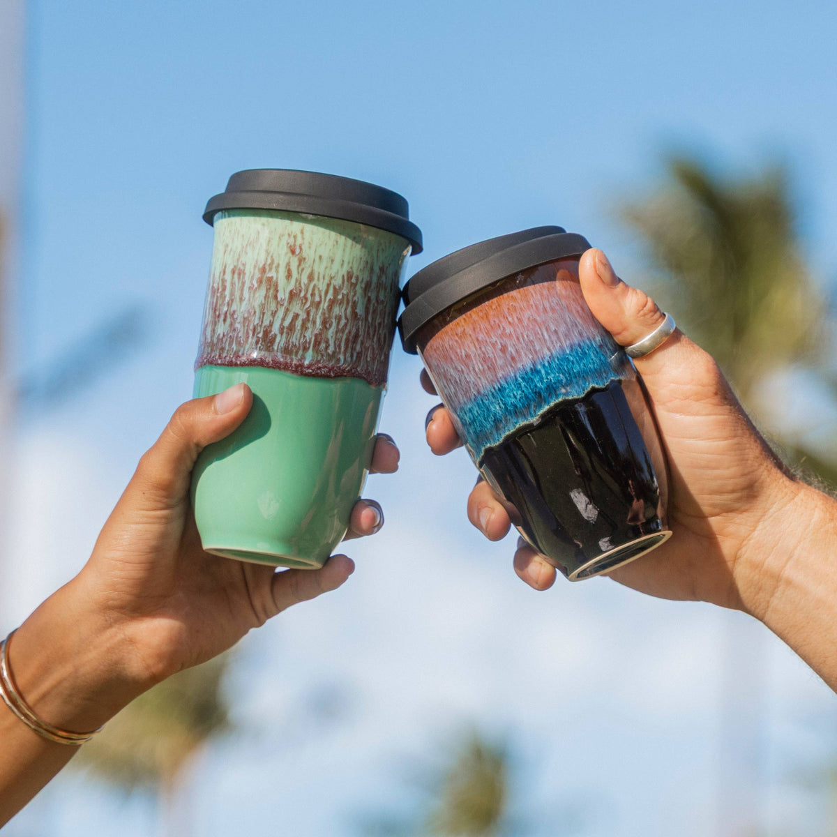 Two sustainable ceramic coffee mugs toasting in Fort Collins eco-friendly coffee shop